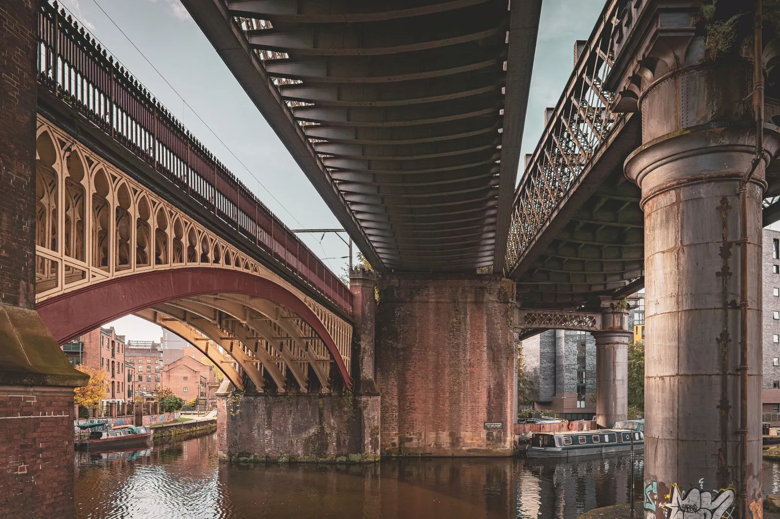 Stunning view of historical bridges over Manchester canal, capturing architectural elegance and urban connection.