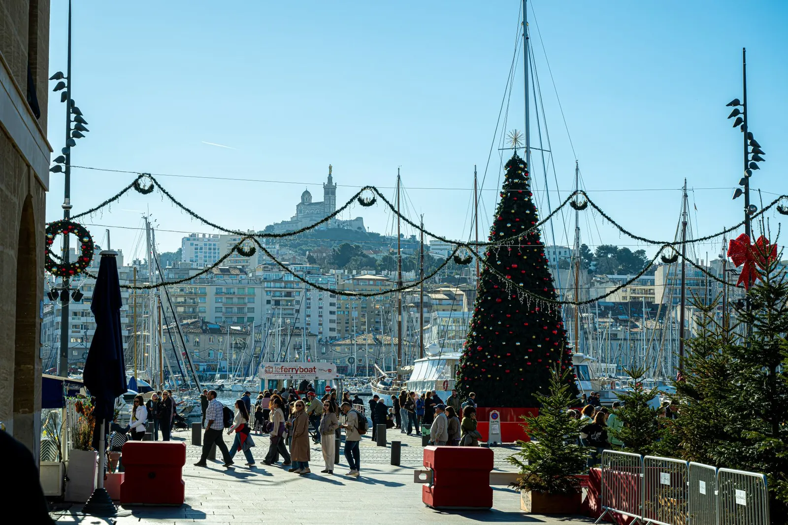 Festive Christmas decorations with a view of Notre-Dame de la Garde at Vieux-Port, Marseille.