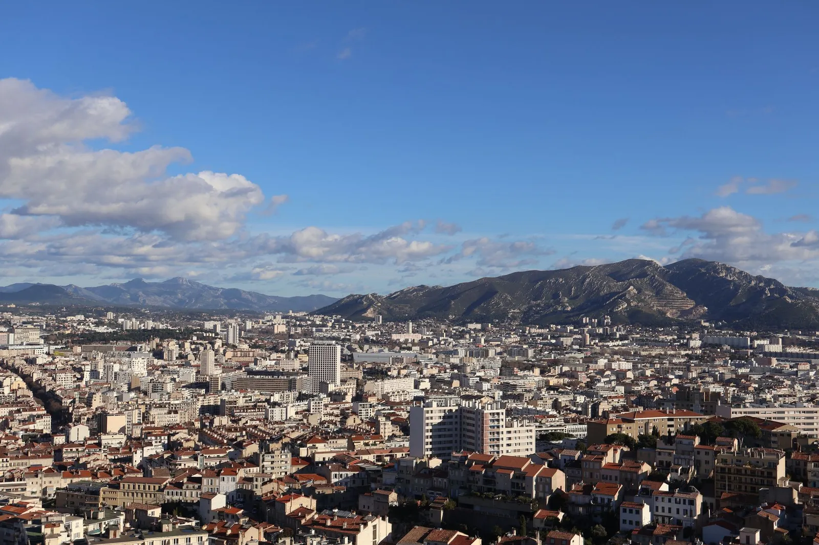 A stunning aerial view of the cityscape of Marseille, France, under a bright summer sky.