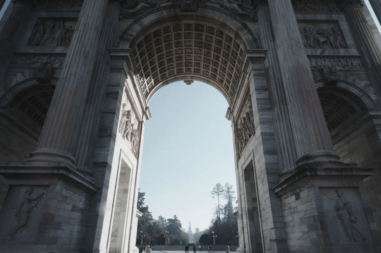 A classic view through the grand arch of Porta Sempione in Milan, Italy.
