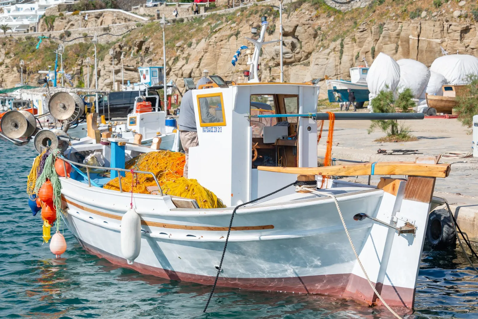 A traditional fishing boat moored at a picturesque coastal port, ideal for seafaring adventures.