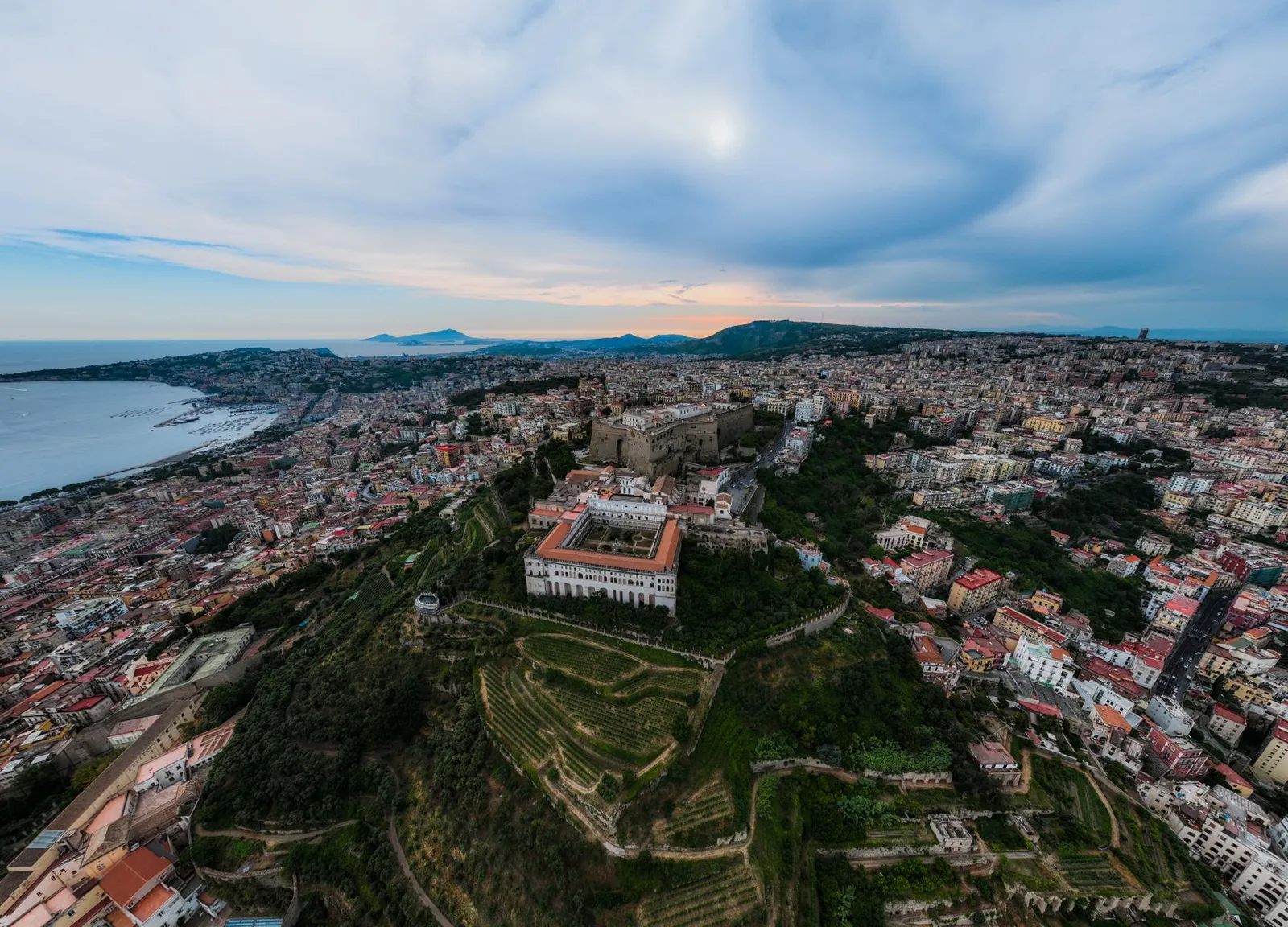 Stunning aerial view of Sant'Elmo Castle and Naples cityscape at sunset.