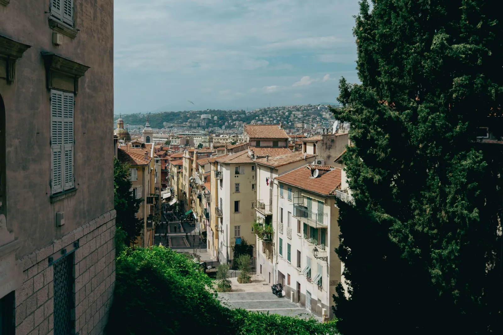 Explore the picturesque streets of Nice with historic architecture and stunning hillside views.