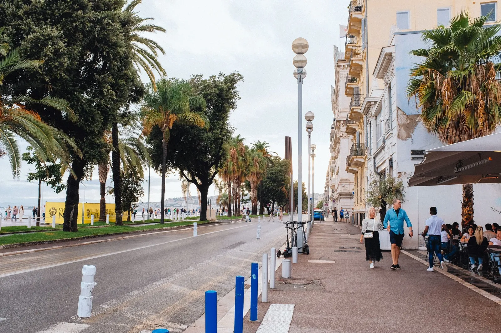 A sunny day at Promenade des Anglais in Nice, with people enjoying the vibrant city street.