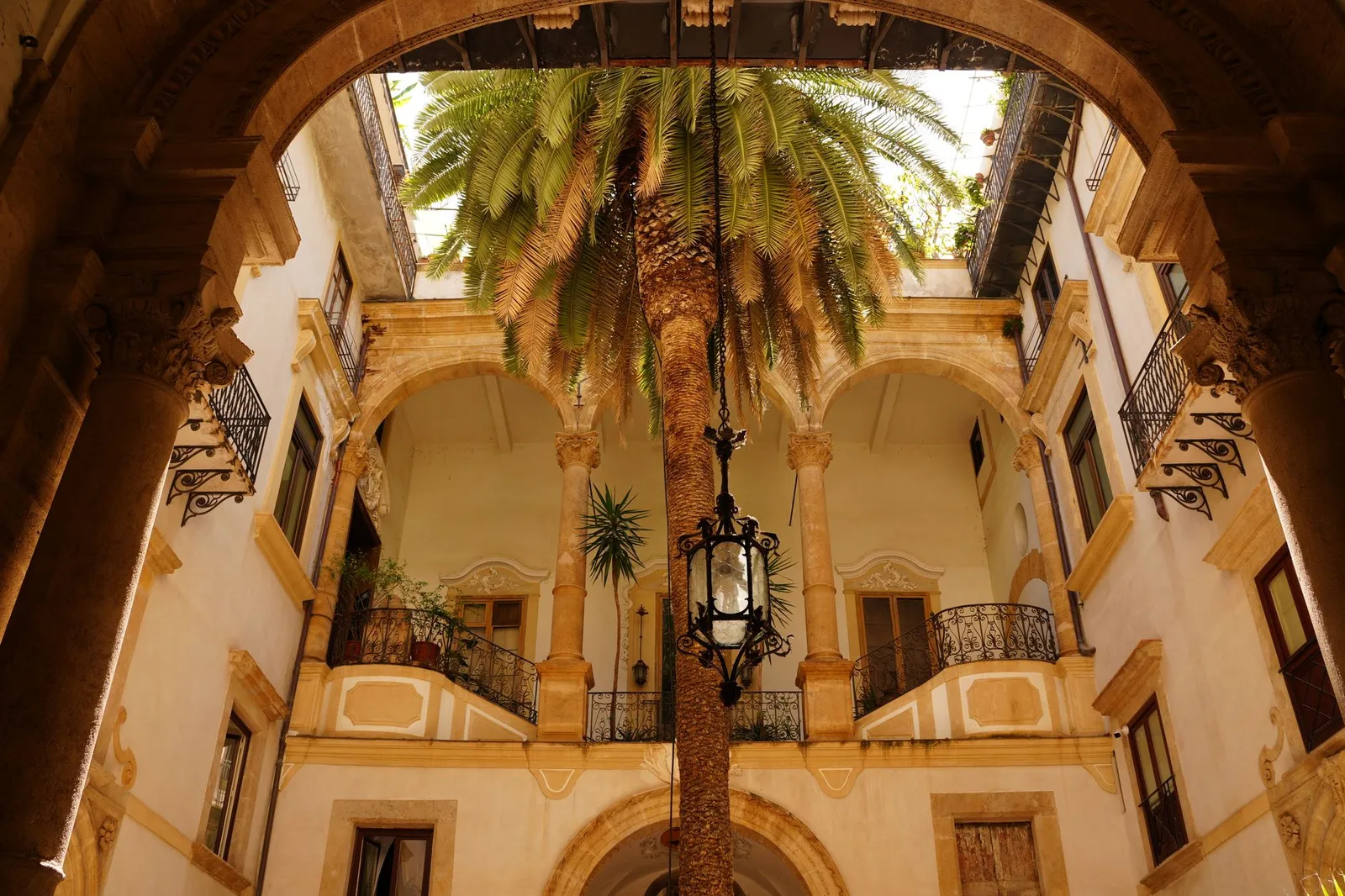 A beautiful view of a historic courtyard in Palermo, Sicily, showcasing classic Italian architecture.