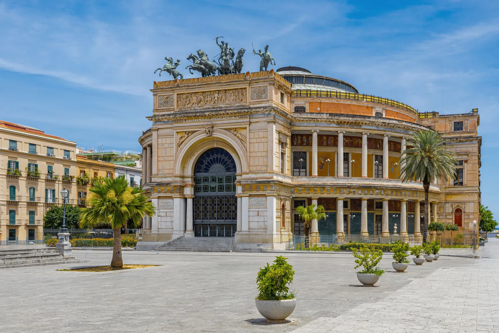 View of Teatro Politeama Garibaldi in Palermo, Sicily, with clear blue skies.