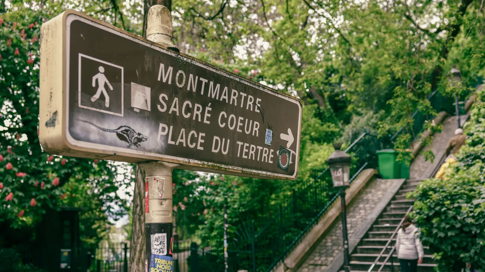 Signpost directing to Montmartre, Sacré Coeur, and Place du Tertre in Paris's scenic area.