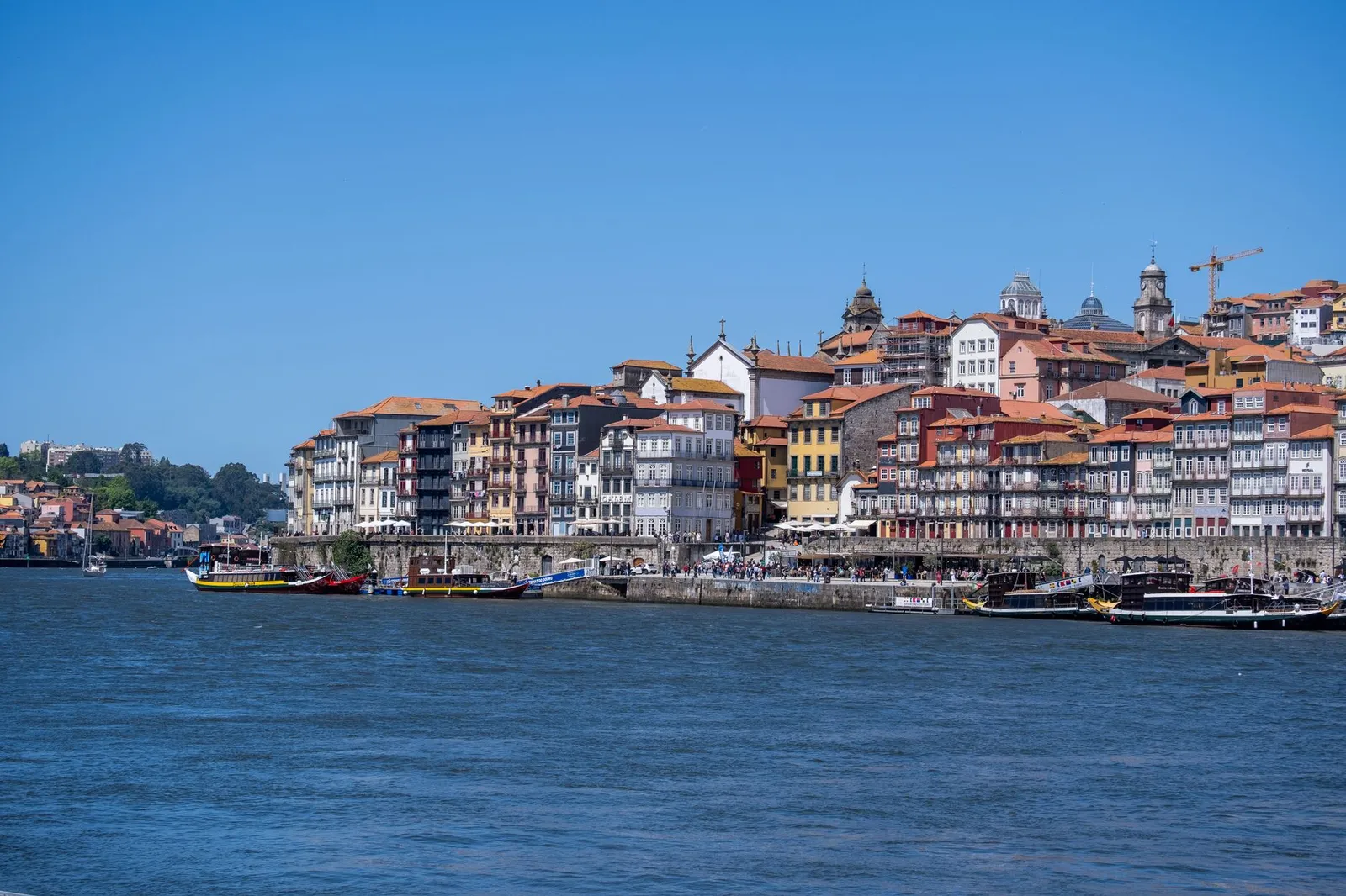 Explore the colorful and historic waterfront of Porto's Ribeira District on a sunny day.