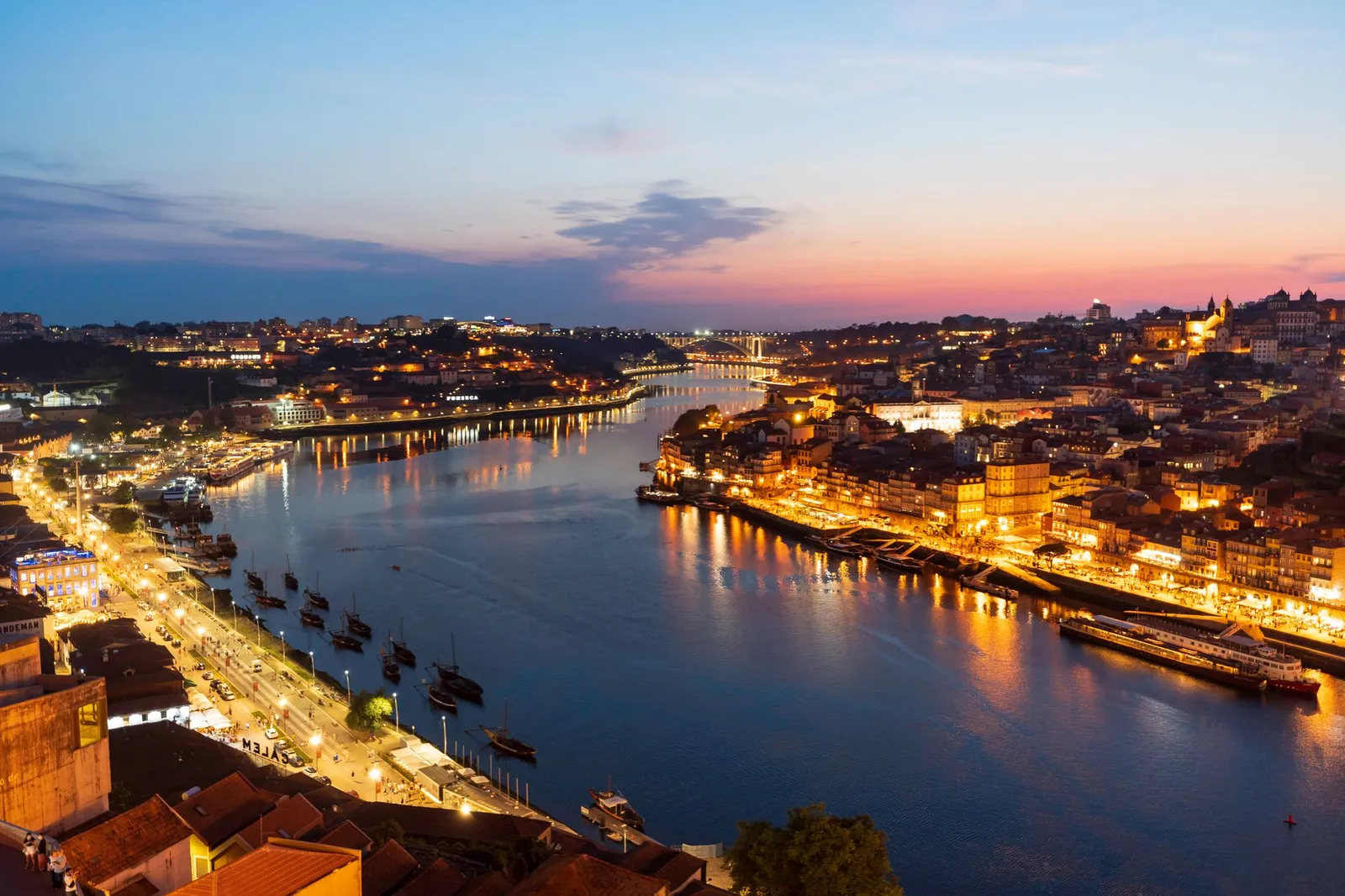 Breathtaking view of Porto's illuminated riverfront at twilight from Vila Nova de Gaia.