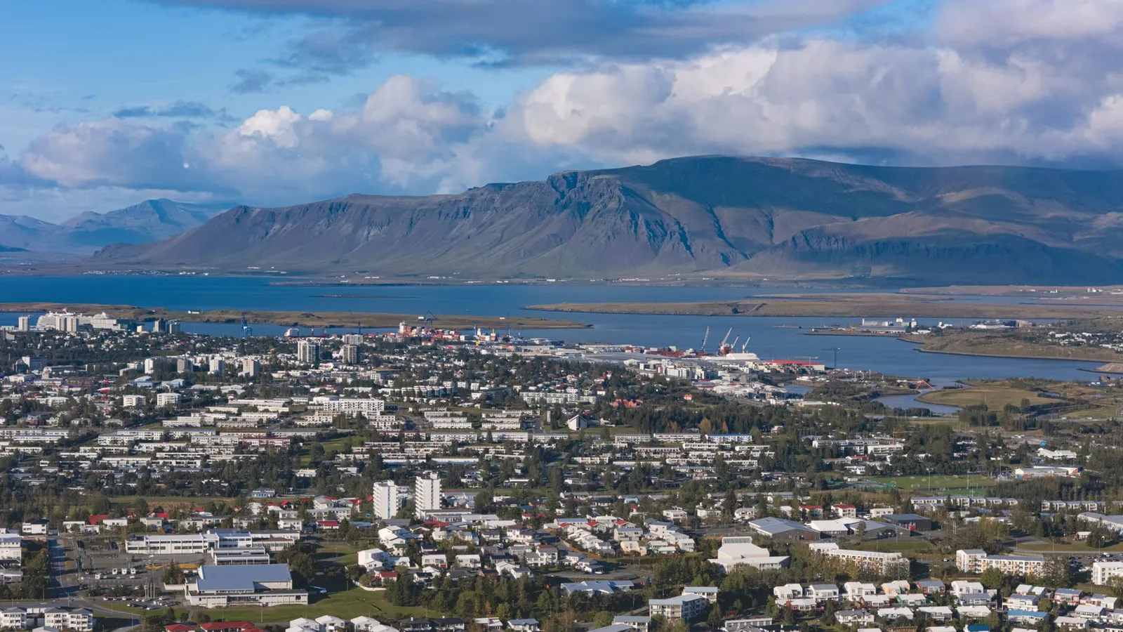 Stunning aerial view of Reykjavik with Esja Mountain in the backdrop during summer.