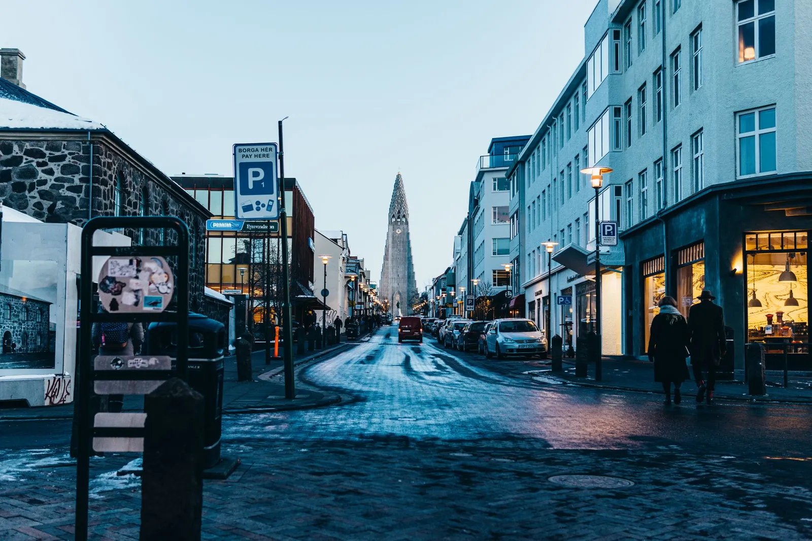 A bustling street view of Reykjavik featuring the iconic Hallgrimskirkja church in winter.