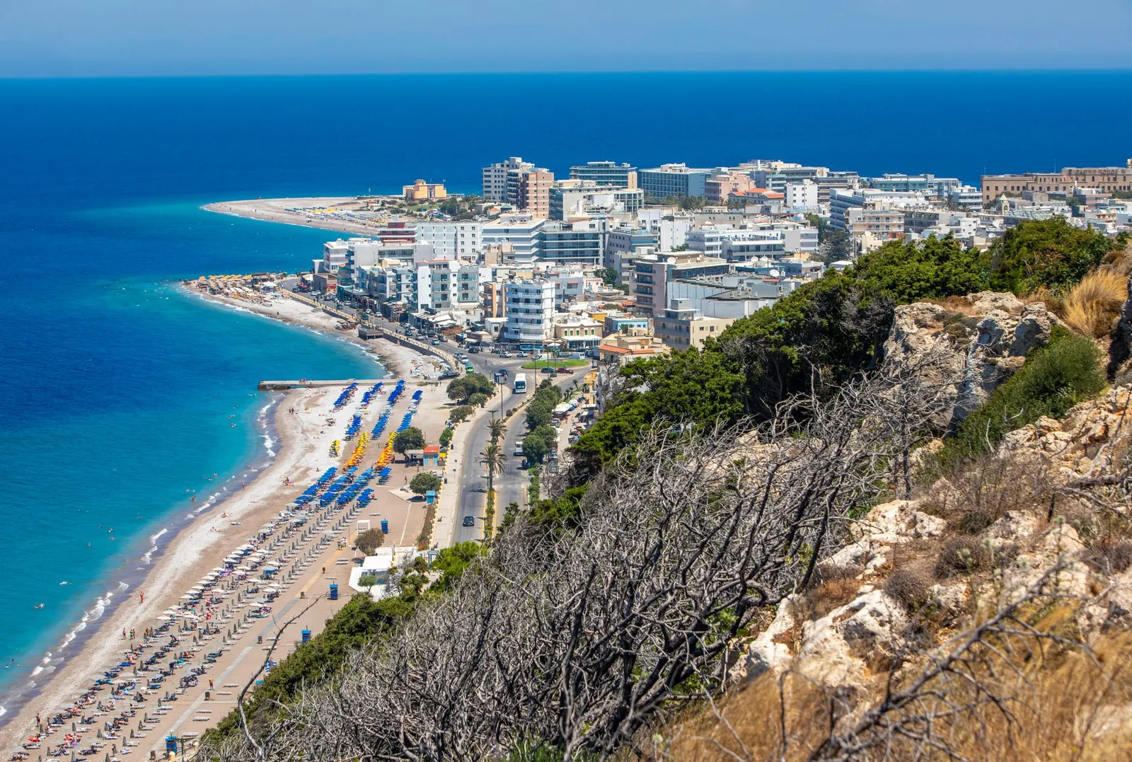 Scenic aerial view of a vibrant beachfront city in Rhodes, Greece, highlighting the summer coastline.