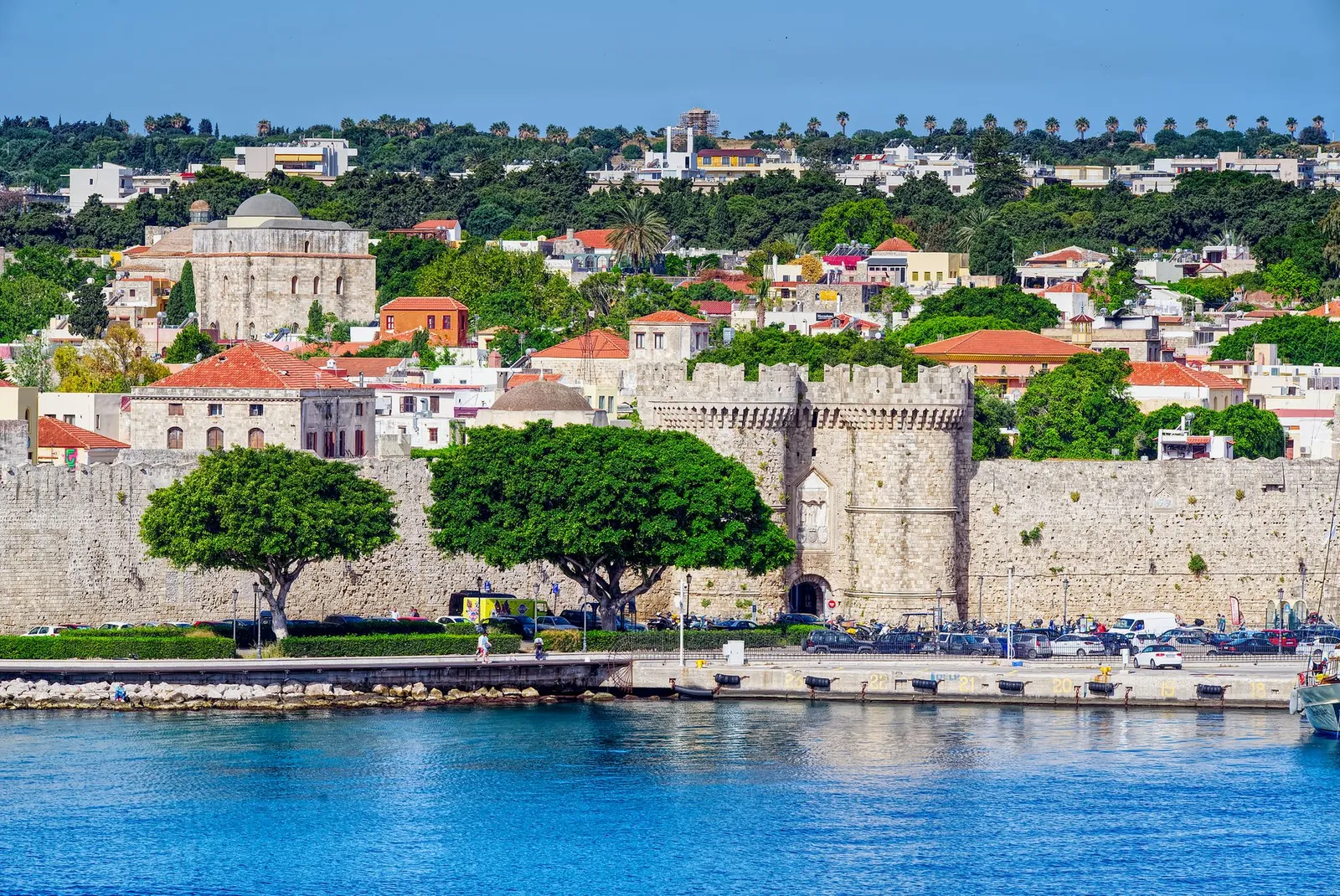 Beautiful view of the historic fortress in Rhodes, Greece, with vibrant cityscape and waterfront.