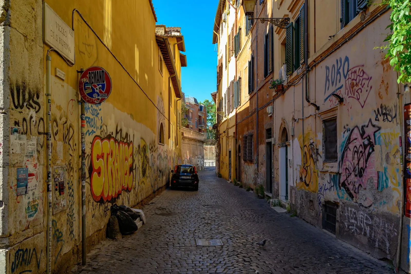 Vibrant street art adorns a narrow cobblestone alley in Rome's historical center.