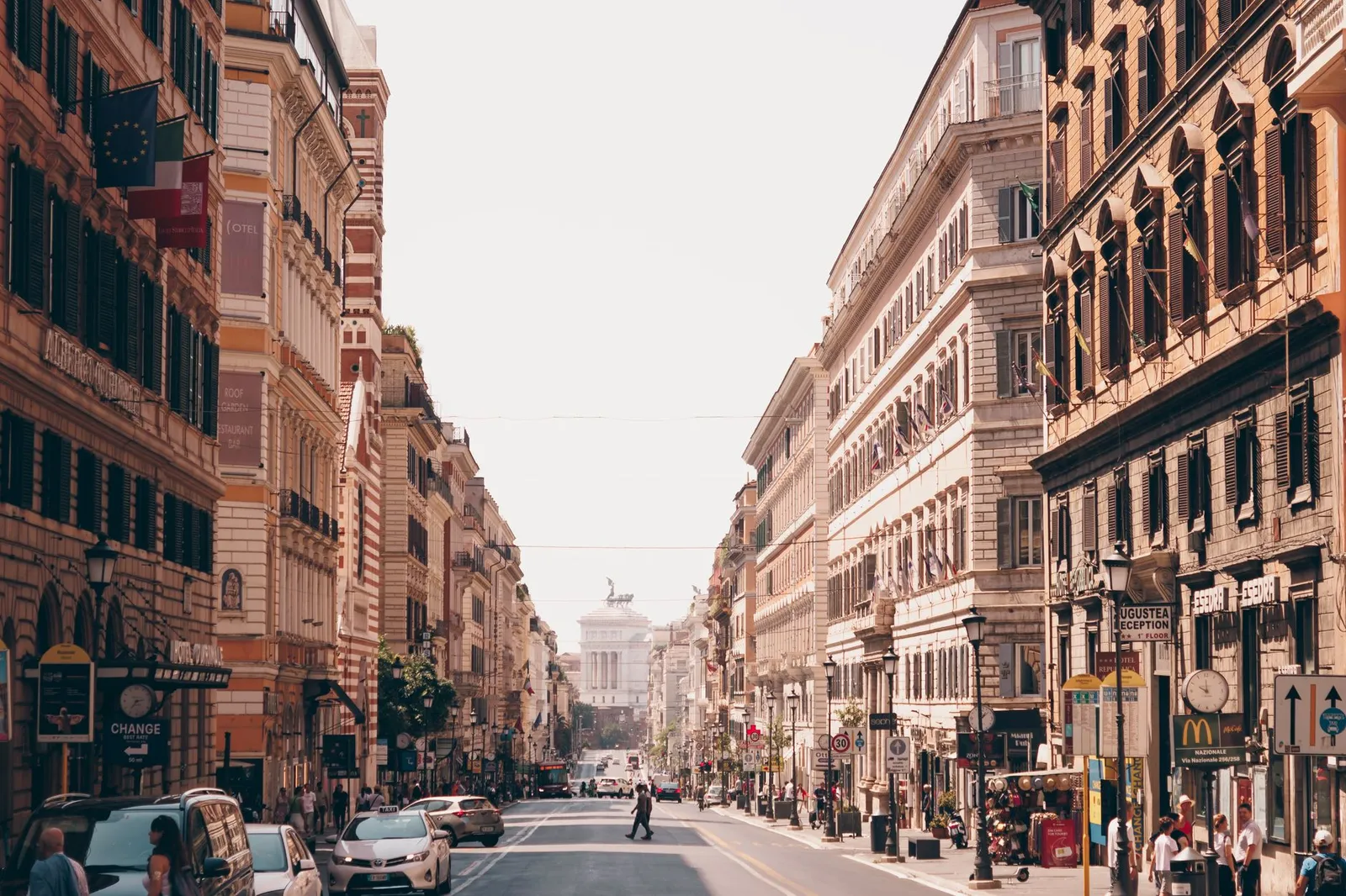 A busy urban street scene in Rome, Italy, showcasing iconic historic architecture and vibrant city life.