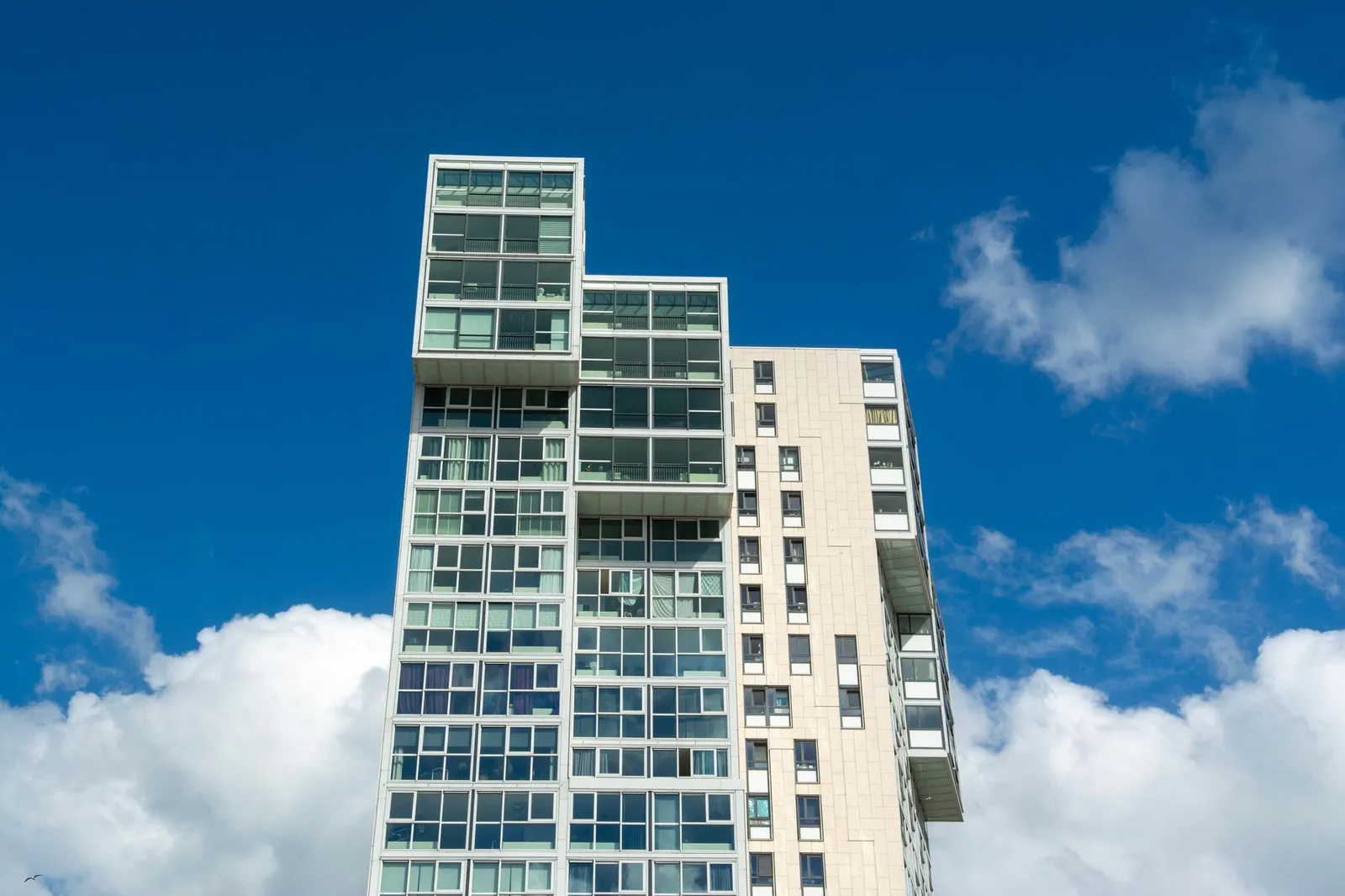 Contemporary architectural design of high-rise building under clear blue sky, Rotterdam.
