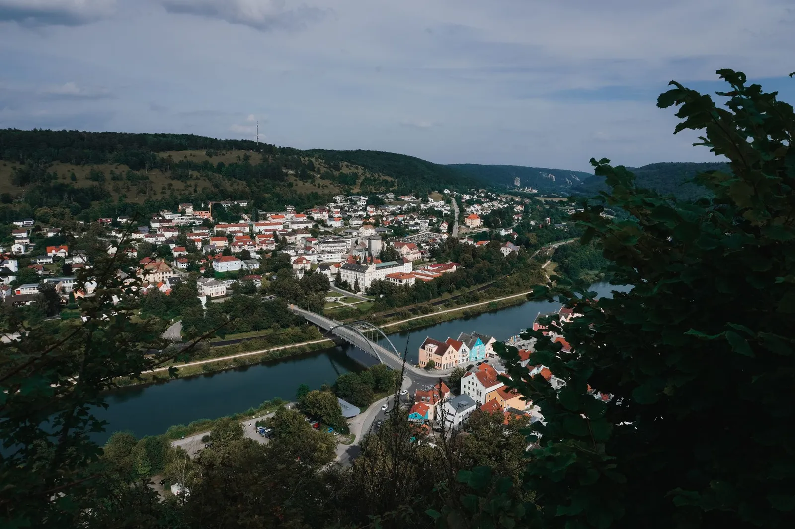 Aerial view of Riedenburg, Germany, showcasing the river, bridges, and lush hills.