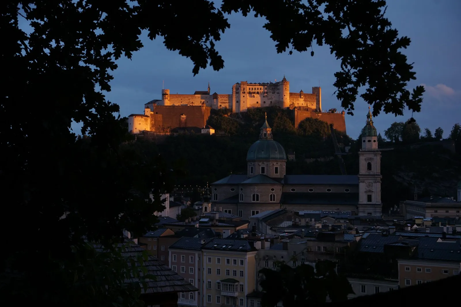 Majestic view of Hohensalzburg Fortress overlooking Salzburg at twilight.