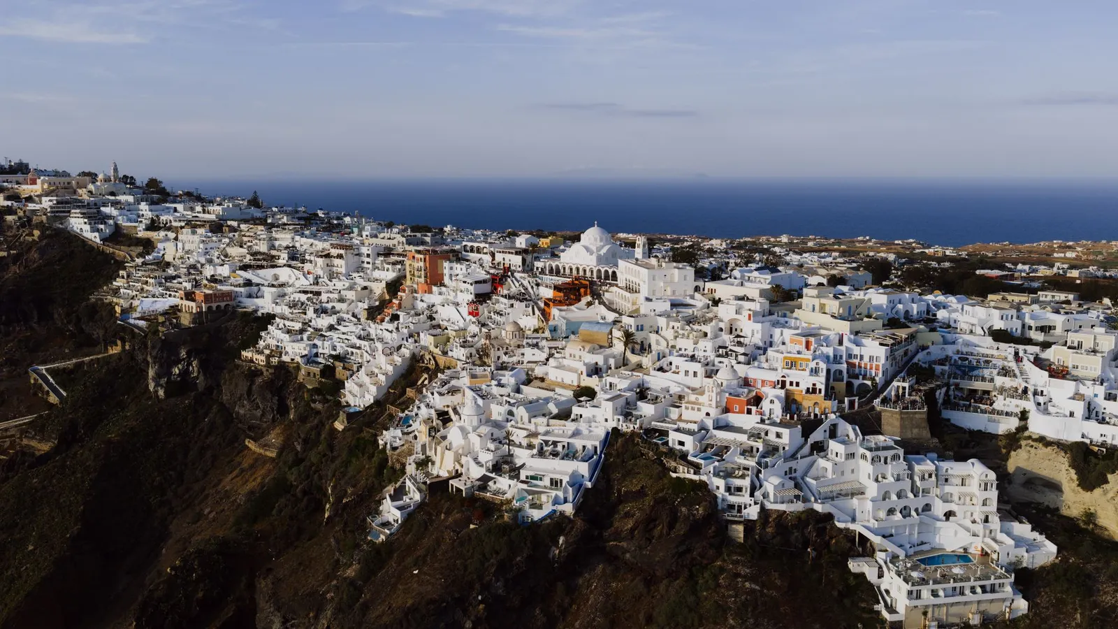 Stunning aerial view of Fira's iconic white architecture against the Aegean Sea.