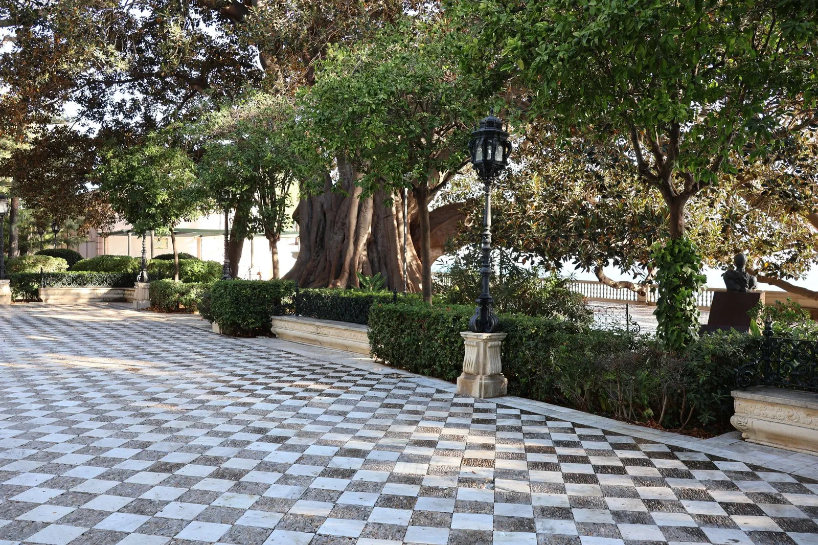 Capture of the serene Alameda de Apodaca gardens in Cádiz, showcasing elegant architecture and lush greenery.