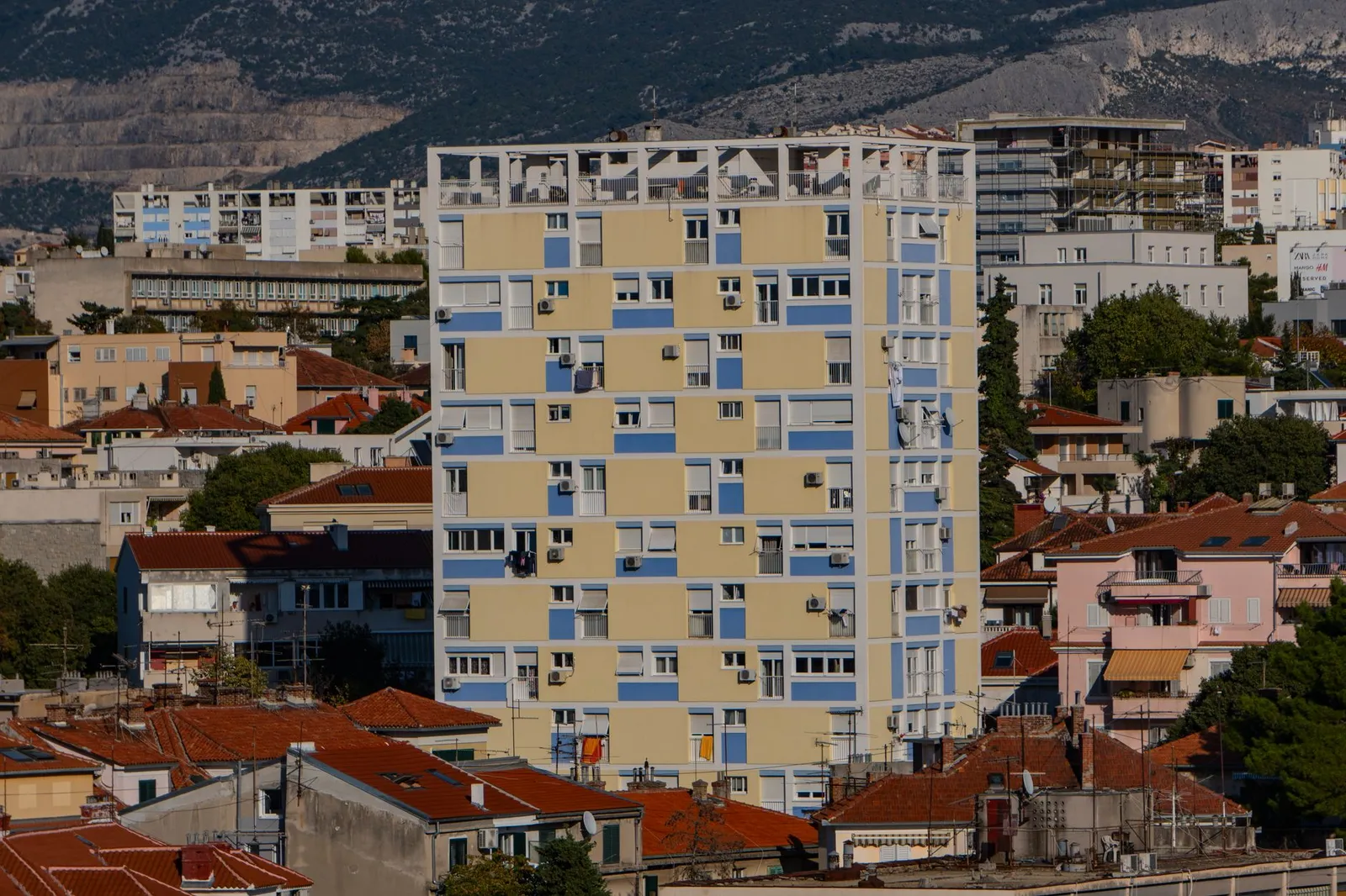 High-rise building amidst traditional rooftops in Split, Croatia's urban landscape.