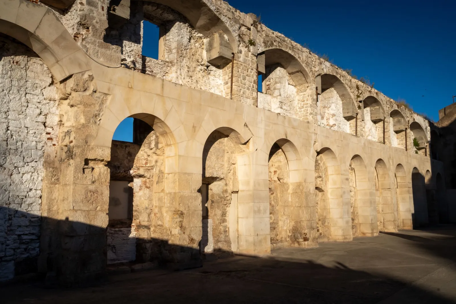 Sunlit Roman architectural ruins in Split, showcasing ancient arches and stonework.