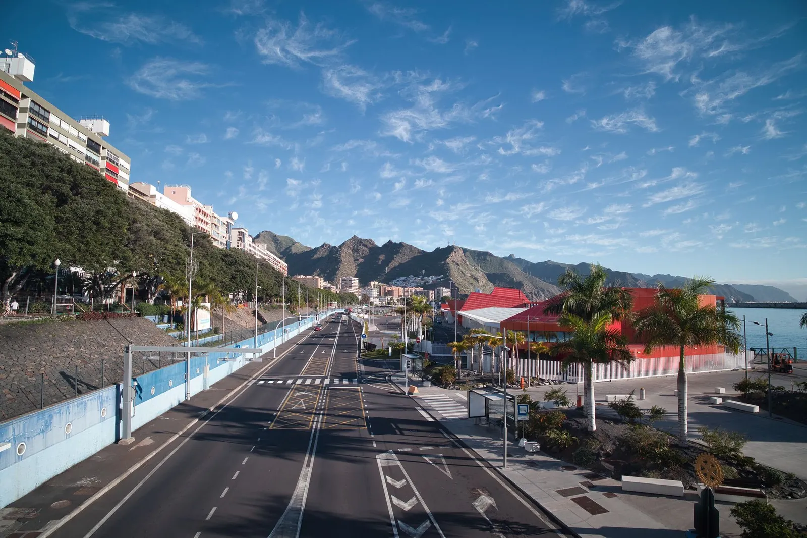 Explore the vibrant cityscape of Santa Cruz de Tenerife featuring colorful architecture and scenic mountains.