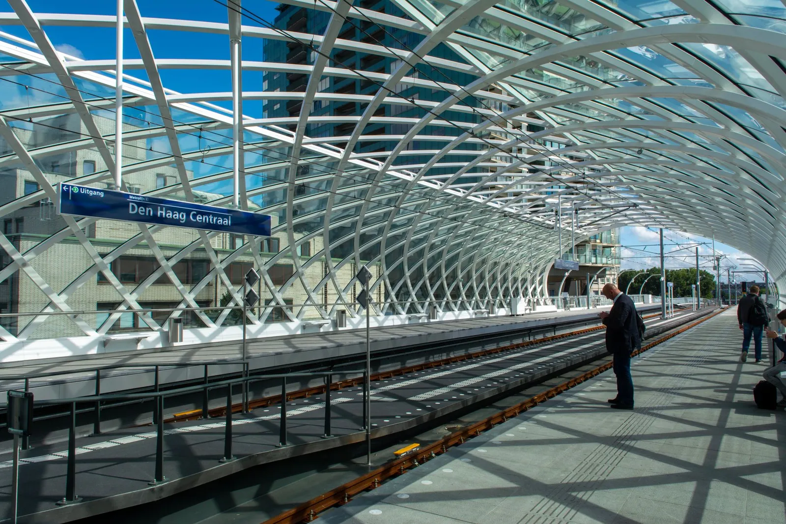Capture of Den Haag Centraal railway station showcasing modern architecture under a sunny sky.
