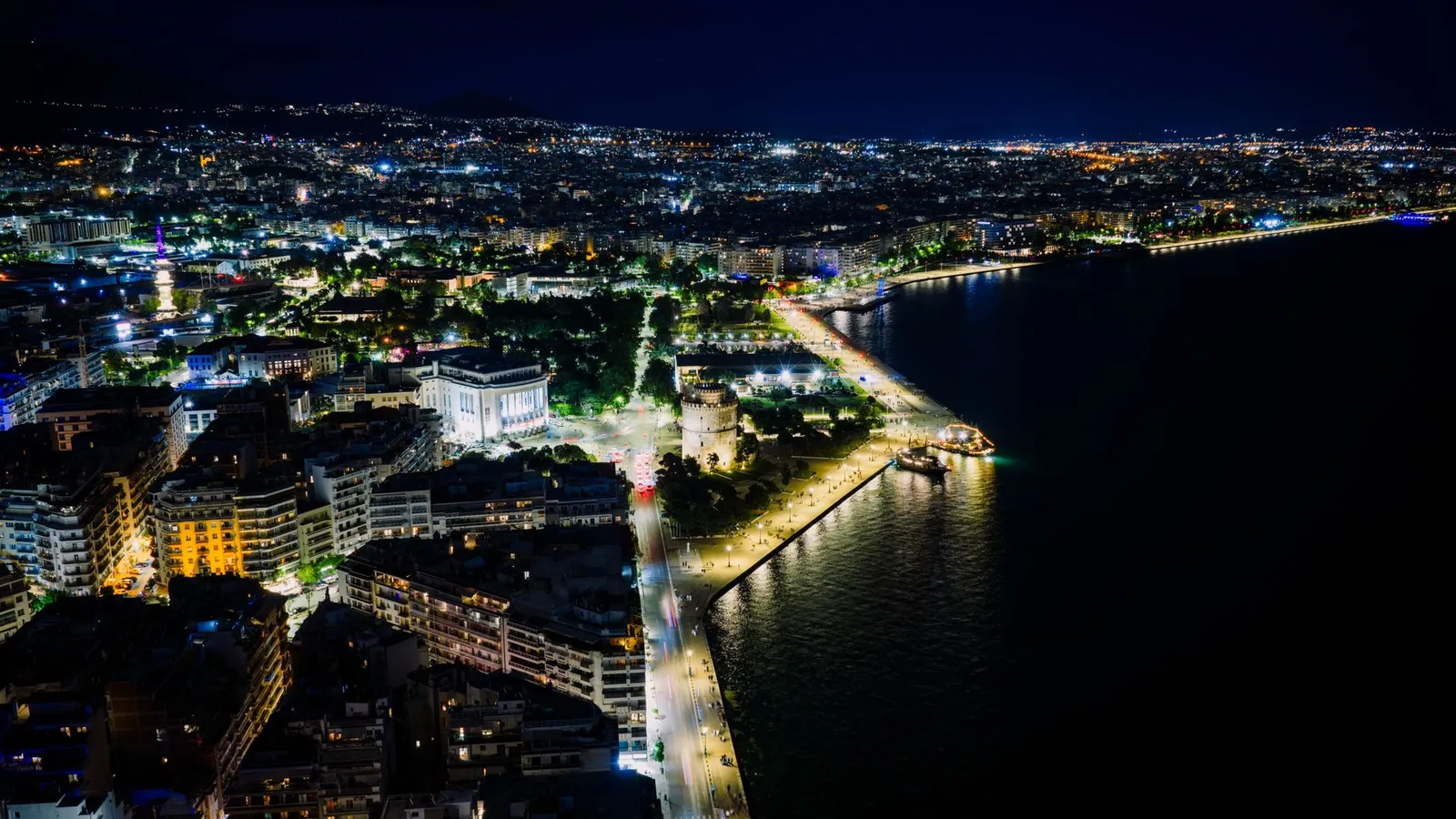 Stunning aerial night view of Thessaloniki's illuminated waterfront in Greece.