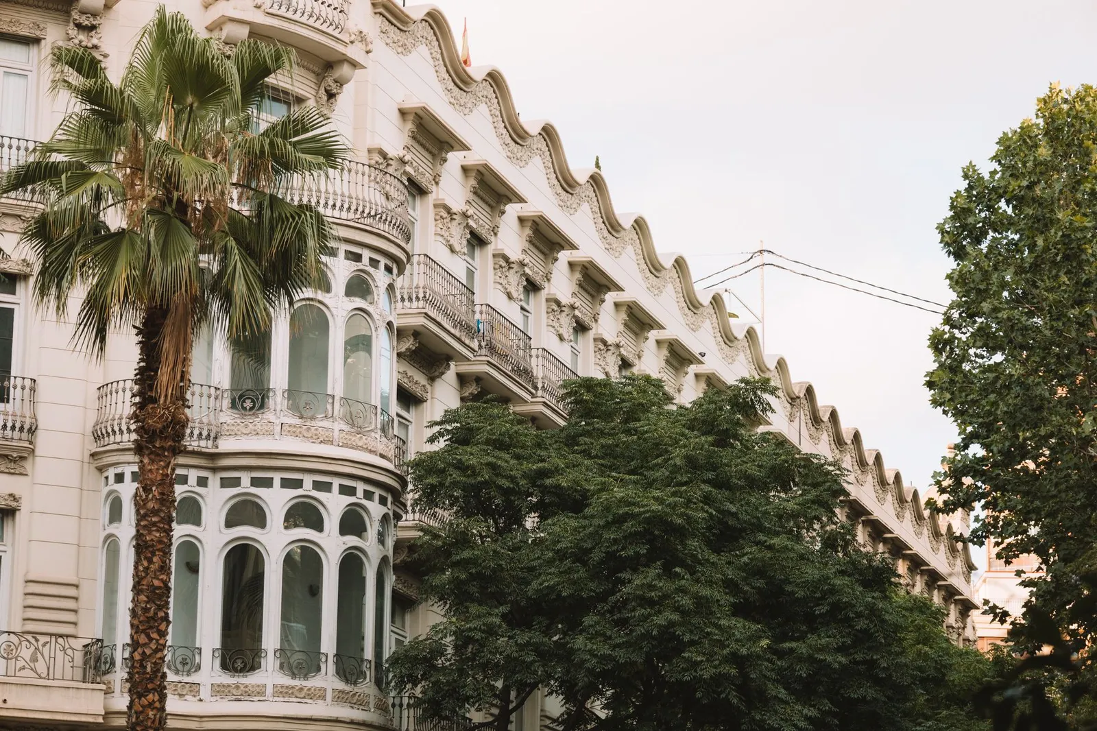Stunning architectural facade in Valencia with palm trees and intricate details.