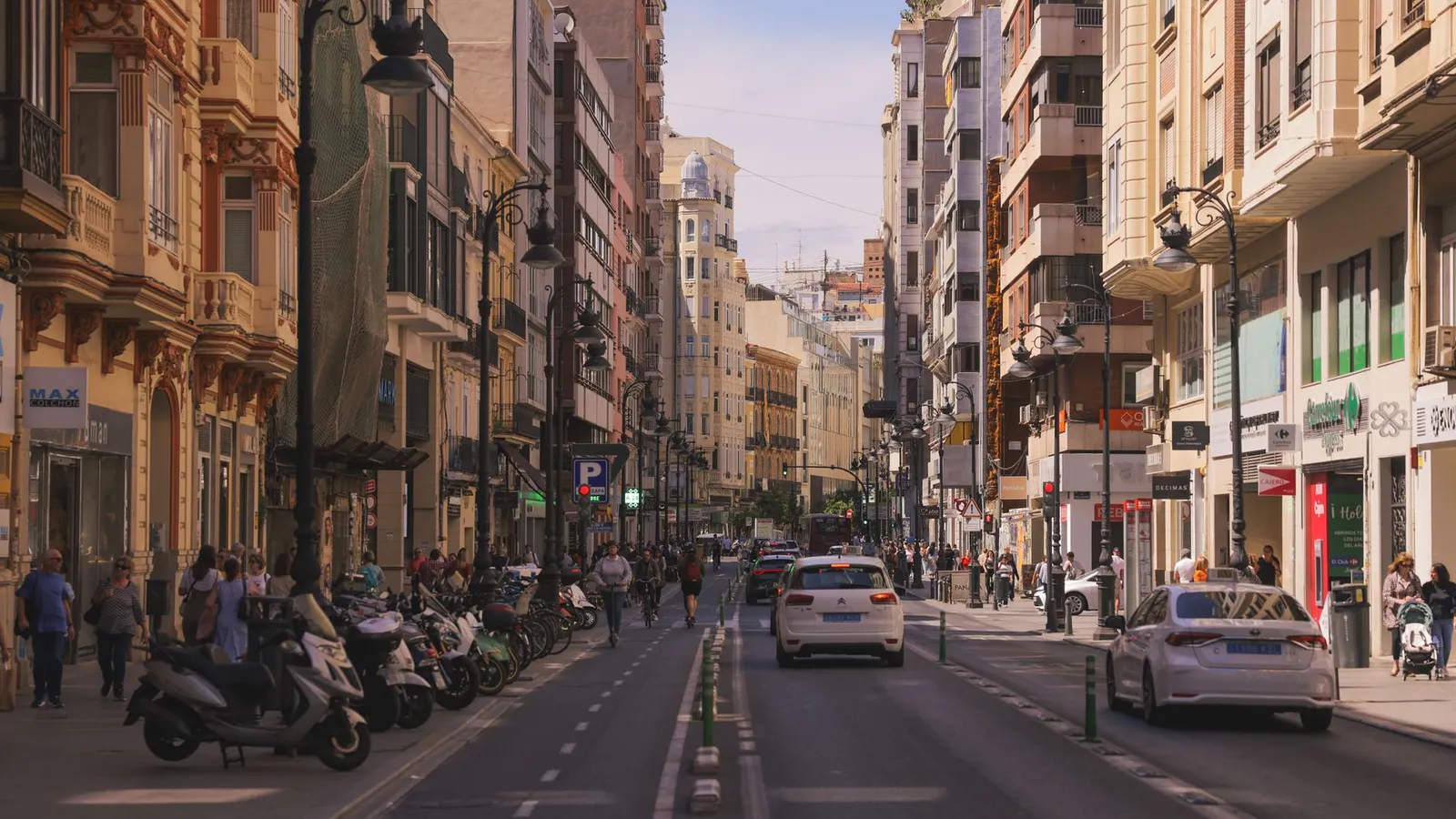 Lively street in Valencia, Spain with classic architecture and vibrant city life.