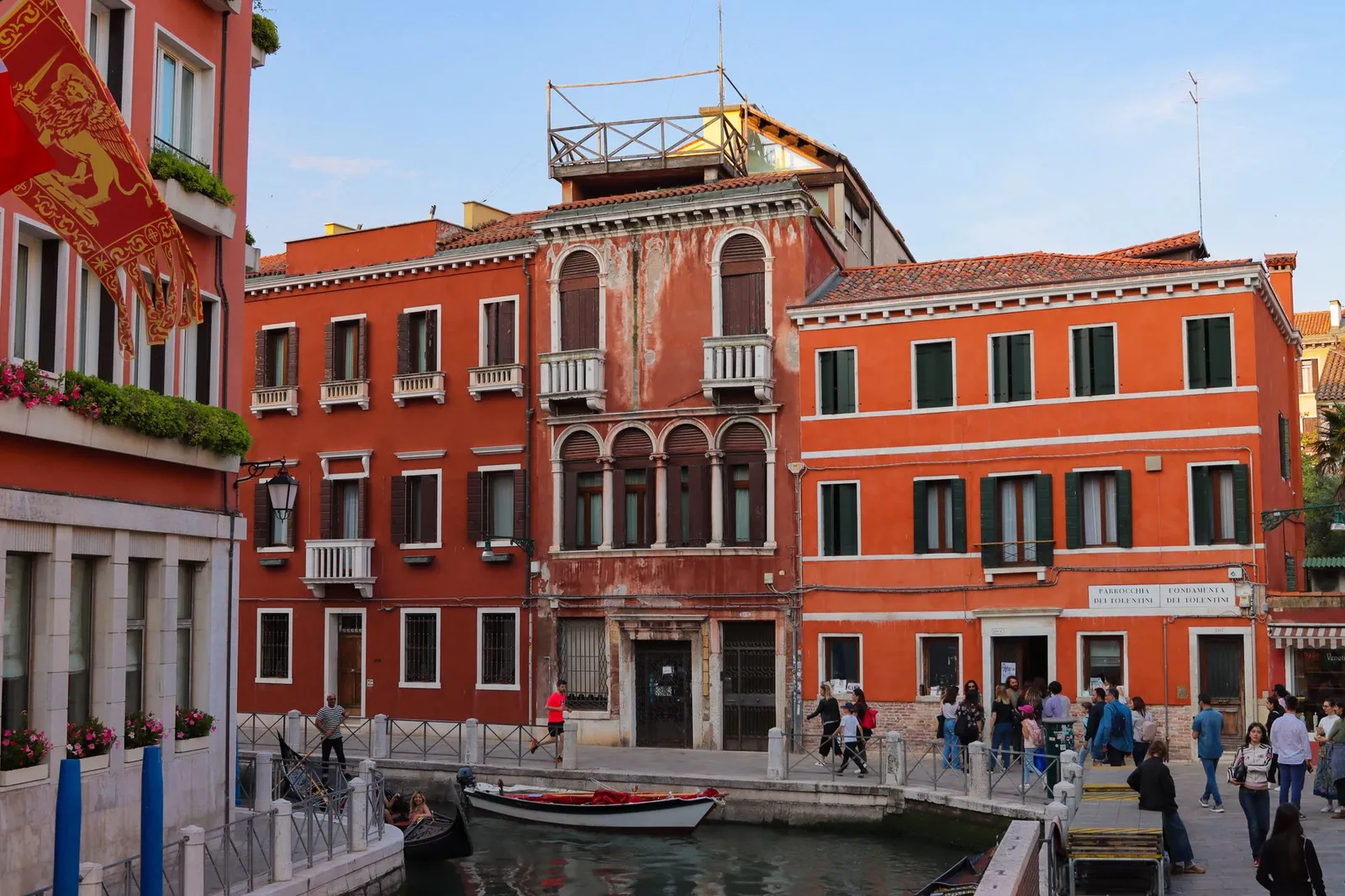 Orange Venetian buildings line a canal in Venice, capturing Italian architecture charm.