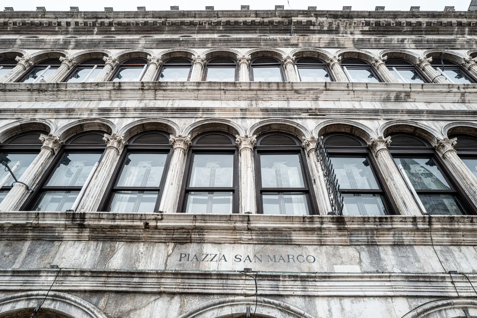 Low angle view of arched windows in Piazza San Marco, Venice's iconic landmark.