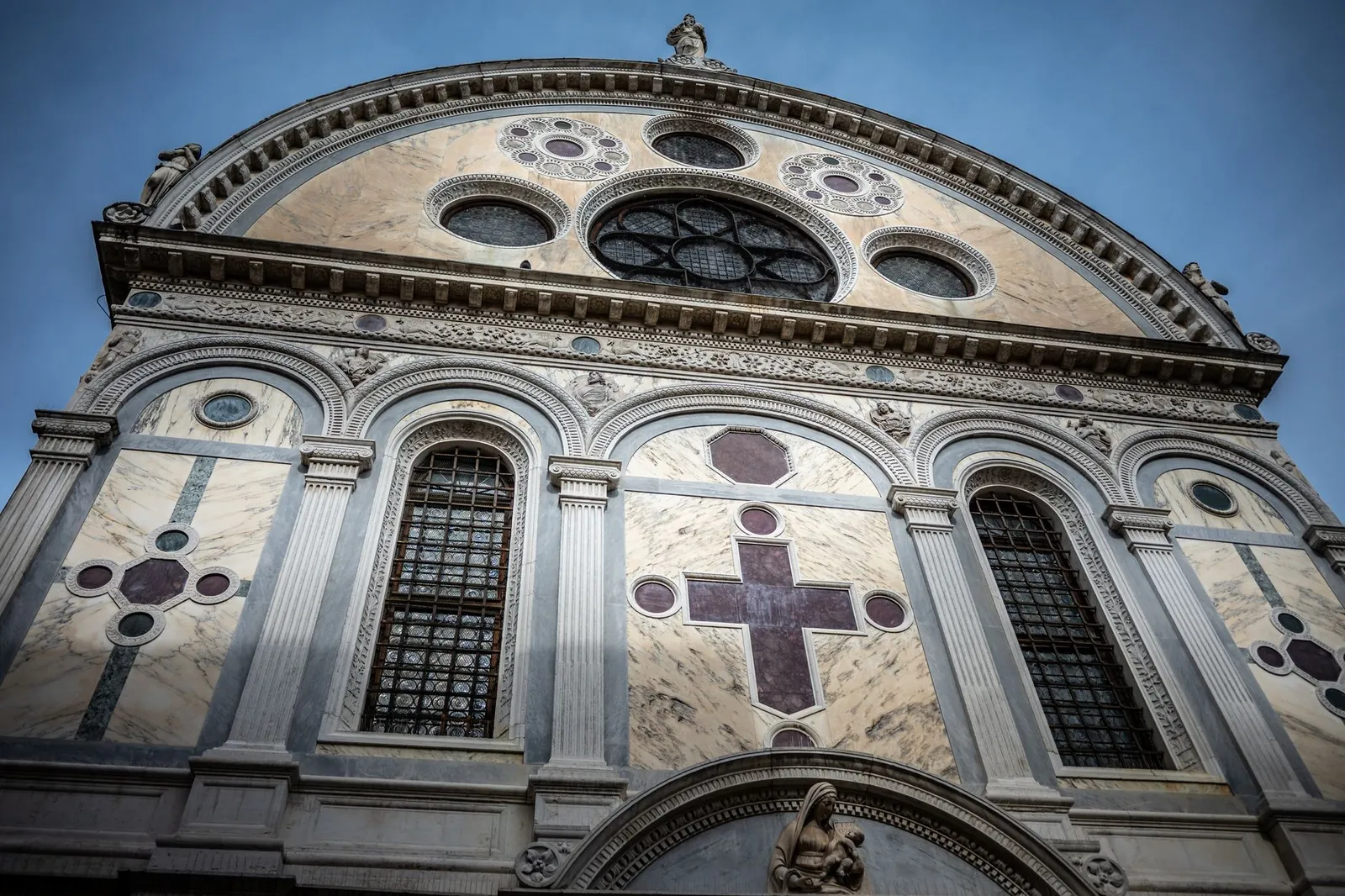 Dramatic view of Santa Maria dei Miracoli's Renaissance façade in Venice, Italy.