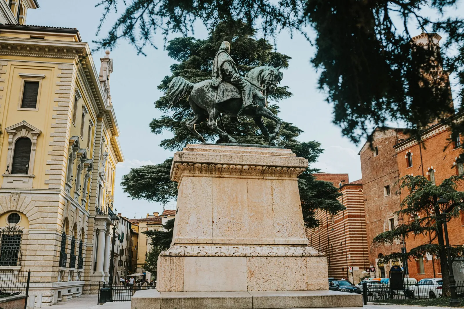 A majestic equestrian statue in Piazza Bra, Verona, surrounded by historic architecture.