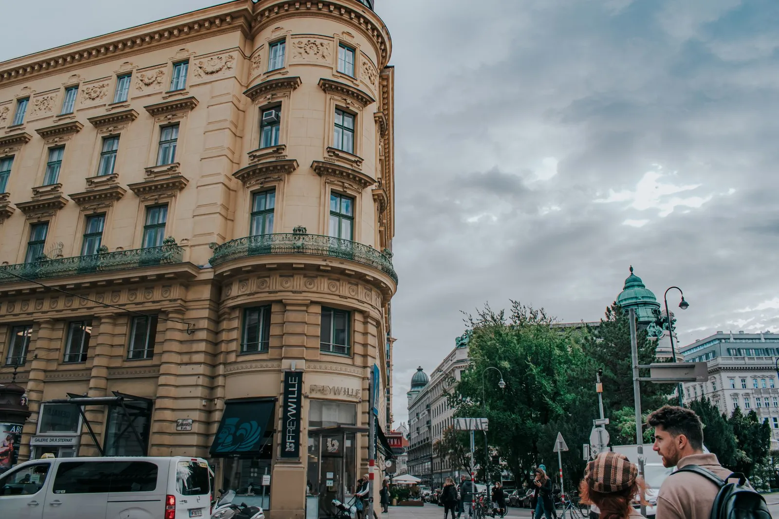 Iconic Vienna streetscape with pedestrians and historic architecture on a cloudy day.