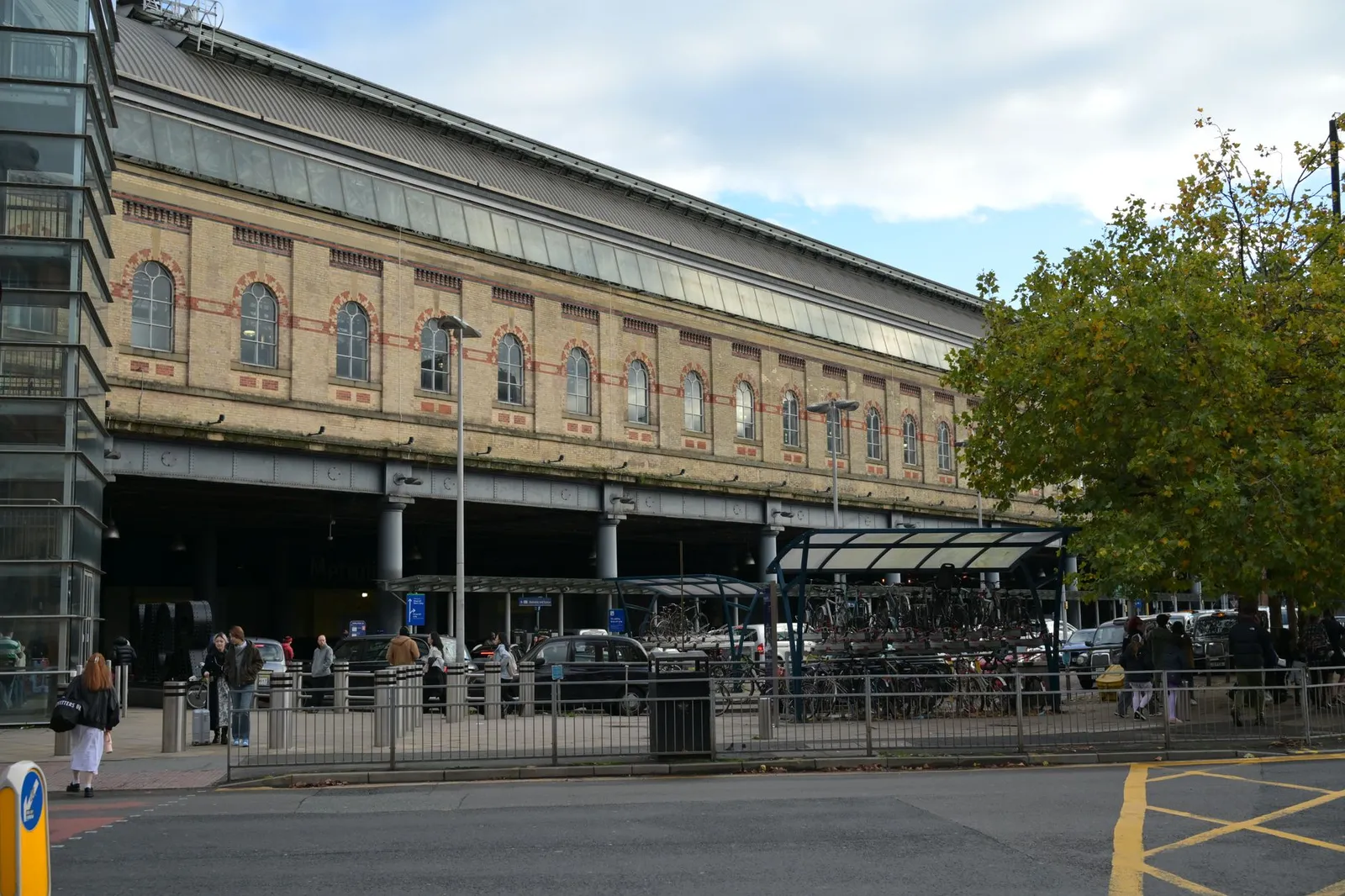 Exterior of York train station with parked bicycles and people nearby.